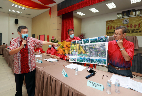 崔福盛(左)要求政府尽快全面完成中环公路,并向会员展示中环公路的图测。