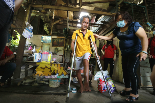 钟亚福的左脚已动两次手术,步行时只能依靠拐杖,右为陈云栏。