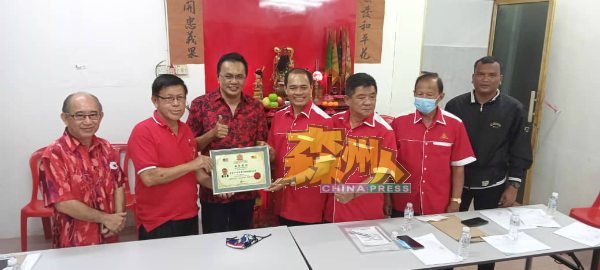 何金泉(右4)颁发纪念状予潘宥磬,由莫哈末沙林(左3)见证。左是龙田俊。