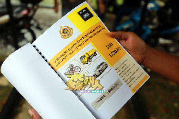 一名有兴趣参与竞标的民众,展示购买的标书。