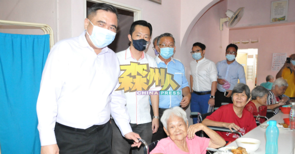 陆兆福(站者左起)、谢琪清及周世扬慰问老人院的老人们。