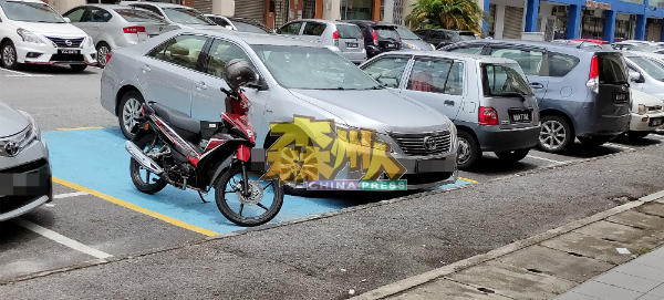 汽车和摩哆一起抢放在残障者专用泊车位。